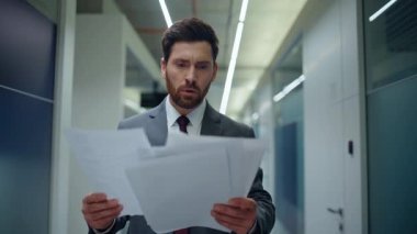 Gergin direktör, modern iş merkezi koridorunu kapatıyor. Gergin iş adamı ofiste stres hissederek kağıtları fırlatıyor. Öfkeli işyeri sahibi para kaybına duygusal tepki veriyor
