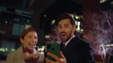 Coşkulu aşıklar gece kentinde akıllı telefondan harika haberler veriyor. Sakallı iş adamı, iş arkadaşıyla cep telefonu paylaşma başarısını yakaladı. İki işletme sahibi tepki gösterdi ve kazandı. 