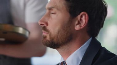 Çağdaş kafede kahve bekleyen düşünceli bir işadamı. Ciddi sakallı adam portresi bilinmeyen garsondan içecek kupası alıyor. Düşünceli yönetici sıcak cappuccino yudumlarken iş üstünde düşünüyor..