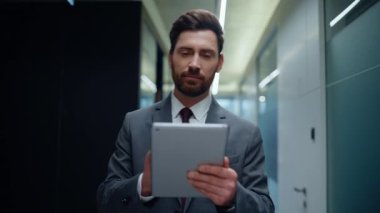 İşadamı elinde bilgisayarla boş bir iş merkezinin önünden geçiyor. Tablet 'teki toplantıyı izleyen girişimci şok oldu. Gergin muhasebeci cihazın mali raporunu okuyor.