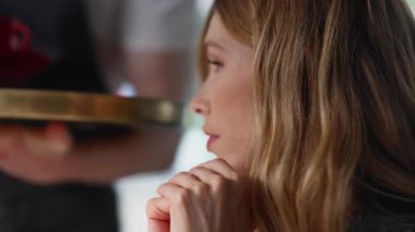 Ressam bayan, güzel bir ifadeyle rahat bir kafede oturmuş garson bekliyor. İsimsiz işçi, güzel bayan müşteriye kahve fincanı getiriyor. Düşünceli sarışın kafeteryada sıcak bir şeyler içiyor..