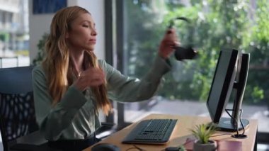 Yardımcı masa çalışanı kulaklık takıyor çalışma masasında modern ofis açık alanda yakın çekim yapıyor. Gülümseyen kadın müşteri hizmetleri temsilcisi müşteriyle konuşuyor. Uzak yönetici destek ve yardım sağlıyor