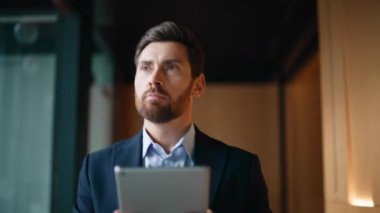 Modern ofis koridorunda yürüyen tablet görünümlü zarif bir çalışan. Kendine güvenen sakallı yönetici bilgisayardaki gezici uygulama salona gidiyor. İş adamı alelacele buluşmaya gidiyor. Gadget 'ta izleme programı..