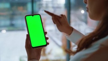 Kullanıcı elleri yakın çekimde internetten cep telefonu seçiyor. Kimliği belirsiz bir kadın yeşil ekranda sosyal medyayı izliyor. İş kadını Chroma Key akıllı telefonundaki bankacılık uygulamasına göz attı
