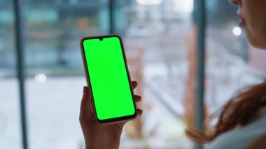 Mockup akıllı telefondan alışveriş yapan bir kadın. Bilinmeyen iş kadını elleri iş yerinde yeşil ekran cep telefonu araklıyor. Krom anahtarlı cep telefonunda serbest çalışan kız gezinme uygulaması