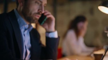 Ajansın iş arkadaşları gece bilgisayarlarında çalışan telefonları arıyor. İş kadını karanlık bir iş yerinde cep telefonundan konuşuyor. İki meslektaş fazla mesai yapıyor..