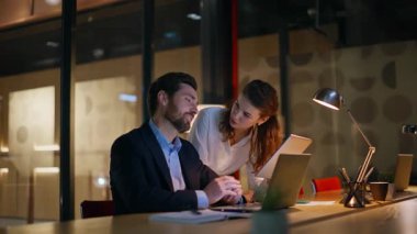 Fazla mesai yöneticileri, akşam çalışma alanında tablet dizüstü bilgisayar stratejisini tartışıyorlar. Akşamları profesyonel girişimciler için proje planlıyorlar. İki iş arkadaşı akşam geç saatlerde iş birliği yapıyor.