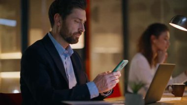 Ofis ekibi akşam ofisindeki cep telefonlarına göz atıyor. Ciddi bir iş adamı, iş yerinde çalışan bir bayanla akıllı telefon mesajı okuyor. Fazla mesai takım arkadaşları birlikte çalışıyor.