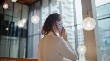Yönetici kadın ofis korkuluklarına yaslanarak cep telefonunu arıyor. Akıllı telefondan konuşan zarif bir iş kadını lobide iş stratejisini tartışıyor. Binada cep telefonuyla konuşan güzel bayan..