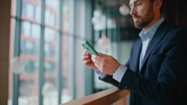 Ciddi bir yönetici cep telefonu mesajını okuyor. Demiryolu ofis lobisinde dikiliyor. Kendine güvenen sakallı iş adamı akıllı telefon uygulamasına bakıyor. Zengin girişimci iş merkezinde telefon mesajları düşünüyor..