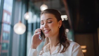 Modern lobide cep telefonundan konuşan bir şirket çalışanı. Başarılı kadın yönetici ofis koridorunda cep telefonunu arıyor. Portre işkadını koridorda akıllı telefon sohbetinden hoşlanıyor..