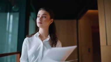 Gergin muhasebeci ofis koridorunda kağıtları inceliyor. Şok olmuş iş kadını, koridordaki umutsuzluğu hissederek belgeleri okuyor. Stresli kadın yönetici belgelerde hata buldu.