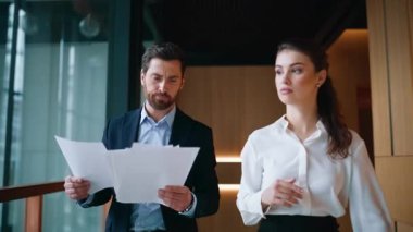 İki yönetici ofis koridorunu kapatıyor. İş kadını, belgelerini okuyan işadamlarına akıllı telefondan kötü haberler veriyor. Endişeli iş arkadaşları koridora kağıt atmakta başarısız oldular.