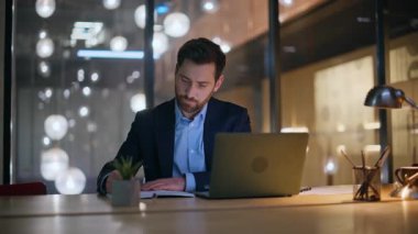 Dizüstü bilgisayar verilerini analiz eden yönetici, akşam iş yerinde oturan bayan meslektaşla yakın çekim yapıyor. Gece ofisinde deftere yazan ciddi bir iş adamı. Fazla mesai yapan çalışkan ekip bilgisayarlara odaklandı.