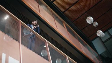 Cam balkon şirketinin ofisinde duran zarif CEO konuşan cep telefonu. Başarılı bir iş adamı iş merkezinden cep telefonunu arıyor. Takım elbiseli sakallı patron akıllı telefon konuşmalarında işi tartışıyor..