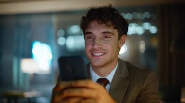 İşadamı gece ofisinde tatmin olmuş bir portre mesajı alıyor. Karanlık işyerindeki cep telefonu mesajlarını okuyan mutlu yöneticiler. Gülümseyen adam telefon ücretinin keyfini çıkarıyor.