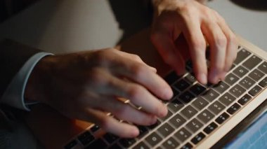 İş adamı, ofis alanındaki yüksek açı çekimde dizüstü bilgisayara e-posta yazarak gece mesaisi yapıyor. İnternet sitesinde klavye taraması yapan tanınmayan bir adam. Bilinmeyen patron akşam çalışıyor.