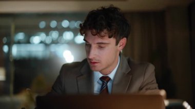 Portre muhasebecisi gece ofisinde lamba ışığında defter yazıyor. Gülümseyen işadamı dizüstü bilgisayarını kontrol ediyor karanlık işyerinde tek başına oturuyor. Kapalı alandaki verileri not eden fazla mesai çalışanı