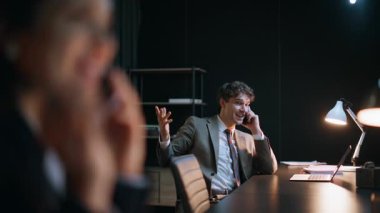 İş adamları gece ofisini arayıp akıllı telefonları kapatıyorlar. Takım elbiseli profesyoneller gece geç saatlerde birlikte çalışan mobil cihazlarla uğraşıyorlar. Hayattan bahseden neşeli iş kadını yüzü