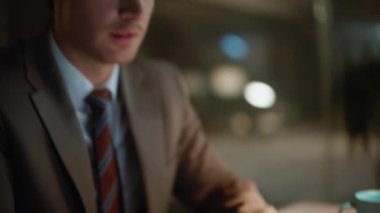 Çalışma masasında klavye daktilo eden gece işçisi. Başarılı gülümseyen işadamı iş belgelerini kontrol ediyor ve akşam ofisinde tatmin oluyor. Yönetici finansal açıdan başarılı görünüyor.