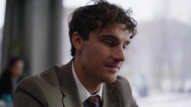 Ofis panoramik penceresinin yanında oturup kafa yorma fikri. Gülümseyen adam iş yerinde proje üzerinde çalışırken bir çözüm buldu. Belgeleri çeviren mutlu iş adamı yaratıcı iş akışının keyfini çıkarıyor