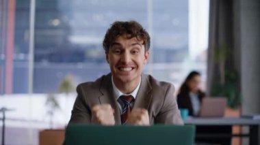 Panoramik ofisteki dizüstü bilgisayarda mesaj okuyan kazanana şaşırdım. Heyecanlı bir iş adamı bilgisayar ekranında galibiyete seviniyor. Mutlu yönetici e-posta alıyor. Komik dans gösterisi başarılı oluyor.