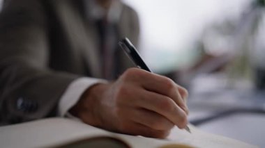 Bilinmeyen yönetici ofiste çalışırken not defterine not alıyor. Elinde kalem tutan bir adam iş hakkında önemli bilgileri el çantasına yazıyor. İşadamı masada oturmayı düşünüyor.