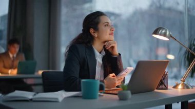 Rahatlamış esmer mesajlaşan akıllı telefon dinlenme odası kapanıyor. Rahatlamış esmer kadın, panoramik cam ile cevap yazan mesajlar okuyor. Büyük pencereli mutlu kadın şeyleri romantik bir ruh hali içinde. 