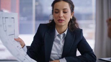 Mimar, ofisteki adam müşteriye planlı numune öneriyor. Neşeli iş kadını iş adamıyla tasarım projesini tartışıyor. Gülümseyen kadın mühendis işyerindeki erkek müşteriye danışıyor 