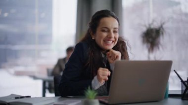 Çevrimiçi çalışan iş yerinde iyi haberler okuyan dizüstü bilgisayara bakıyor. Yakın plan. Takım elbiseli gülümseyen kadın sevinç projesi bilgisayarda sonuçlandı. Mutlu bayan, konferans salonunda iş başarısı hissediyor.