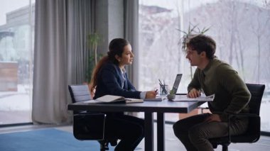 Modern ofisteki resmi toplantıda müşteri ve yönetici sözleşme detaylarını gözden geçirir. Esmer iş kadını açık panoramik kabinede müzakereleri başarıyla tamamlıyor. İş ve ortaklık kavramı 