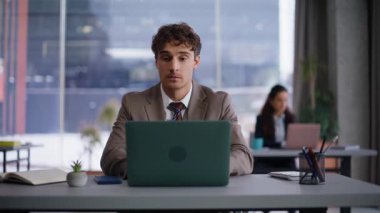 İş yerinde odaklanmış idari düşüncenin çözümü. Ofisteki laptopta çalışırken ciddi bir yaratıcı fikir gibi görünüyor. Yakışıklı iş adamı, proje yazma sorunları yaşıyor. 