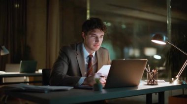 Gece muhasebecisi karanlık ofiste belgeleri inceliyor. Fazla mesai yöneticisi bilgisayar ekranında kahve yudumlarken eğleniyor. Laptopta gülümseyen adam lamba ışığında oturmuş evrak işleriyle uğraşıyor.