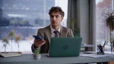 Ciddi bir iş arkadaşı cep telefonuna bakıyor ve yakın çekimde mesaj alıyor. Hayal kırıklığına uğramış işadamı, para okurken, akıllı telefonda umutsuzluktan banka tebligatını kaybetti. Duygusal yönetici sorundan memnun değil 