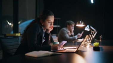 Akşamları iş arkadaşları karanlık çalışma alanında akıllı telefonlara mesaj atıyor. Ofis ekibi geç saatlere kadar bilgisayar işyerinde çalışıyor. Sıkıcı esmer iş kadını. Şirket ofisinde cep telefonuna mesaj atıyor.