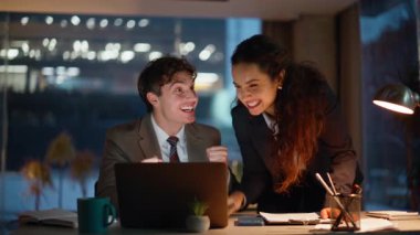 Keyifli ortaklar dizüstü bilgisayardan e-posta okuyup panoramik pencerede beş kişi görüyorlar. Başarılı bir başlangıca duygusal meslektaşlar tepki veriyor. İki iş arkadaşı birlikte iş başarısını kutluyor.