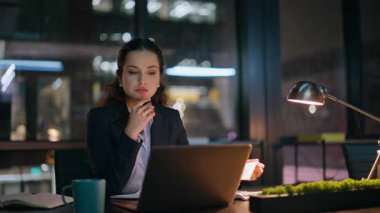 Bayan yönetici gece ofisinde evrak işleriyle uğraşıyor. Fazla mesai yapan bilgisayar uzmanı karanlık dairedeki mali raporları kontrol ediyor. Lamba ışığı altında çalışan odaklı kadın belgeleri okuyor