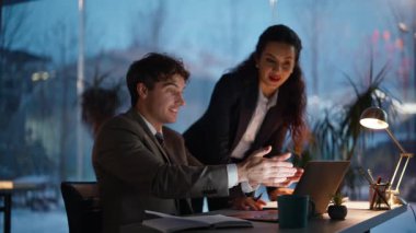 Kadın patron yönetici, gece ofisinde çalışıyor. Yakın plan çekimde çalışıyor. Gülümseyen iş kadını beş adama iş arkadaşı veriyor. Arkadaş canlısı şirket koçu, stajyerlerin sevinç dolu başarılarıyla tecrübesini paylaşıyor.