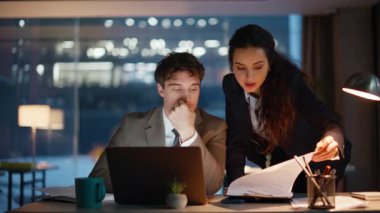 Mutlu iş arkadaşları iş projesinde birlikte beş iş birliği yapıyor. Gülümseyen kadın erkek, akşam ofisinde başarılı bir iş arayan dizüstü bilgisayar görünce seviniyor. İş yerinde ortaklığın keyfini çıkaran iki iş arkadaşı