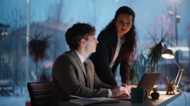 Dost canlısı akıl hocası, ofisteki stajyere dizüstü bilgisayarda yardım ediyor. Kendine güvenen bir kadın, akşam vakti iş yerinde oturan bir adamla konuşuyor. İki zeki iş arkadaşı ofiste iş stratejisini tartışıyor.