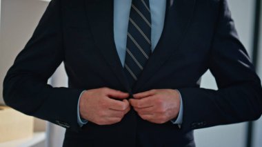 İş adamı elleri spor ceketin düğmelerini bağlıyor ve aynaya şakayla işaret ediyor. Takım elbiseli sakallı adam modern gardıroba bakıyor. Kendine güvenen yönetmen tek başına yeni kıyafet seçer.