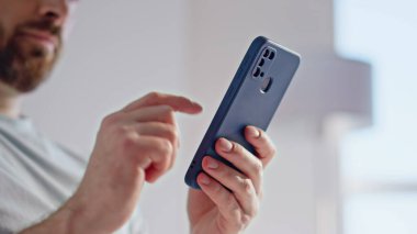 Sabahları ışık odasında oturan akıllı telefon ekranını parmaklayan bir adam. Gülümseyen sakallı adam internetten sipariş verirken Beyaz Ev 'de mutlu oluyor. Kapalı alanda cep telefonu kullanan pozitif esmer.