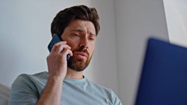 Üzgün esmer, evde akıllı telefonlardan konuşuyor. Yorgun işadamı evde cep telefonuyla iş sorunları tartışıyor. Cep telefonuyla konuşan endişeli adam evde kötü haber veriyor.