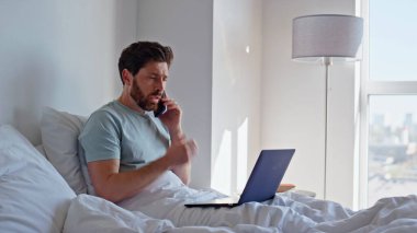 CEO 'nun cep telefonundan yakınıp yatağı kapatmasından endişe ediyorum. Sinirli iş adamı yatak odasında iş sorunları hakkında kötü bir akıllı telefon konuşması yapıyor. Hasta adam evde doktorla cep telefonu konuşuyor. 