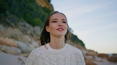 Turist, klasik kamerayla akşam kumsalını çekiyor. Güzel sahil şeridini yakından geziyor. Romantik genç kadın deniz güzelliğinin videosunu kaydediyor. Rahat bayan sahil manzarasında tatil anılarını kaydediyor..