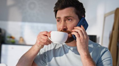 Sabahleyin elinde kahve fincanı olan bir adam akıllı telefonu arıyor. Orta yaşlı yakışıklı işadamı cep telefonundan konuşup hafif mutfakta içkinin tadını çıkarıyor. Neşeli, rahat adam sıcak çayı tek başına içiyor.