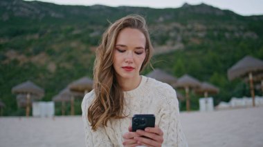 Okyanus kıyısında mesaj yazan gezgin rüzgarlı bir sabahta dinleniyor. Rahat bir kadın cep telefonuna mesaj atıp yeşil tepelerde kumsalda oturuyor. Sakin esmer sahilde cep telefonu kullanarak mesaj gönderiyor.