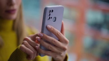 Akıllı telefondan internetteki uygulamayı kullanarak sipariş veren bir kadın. Ofis penceresinde cep telefonu mesajı okuyan gülümseyen bir iş kadını. Rahat bayan bankacılık uygulaması tatmin olmuş hissediyor.