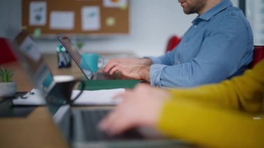 Odaklanmış yöneticiler ofis iş yerinde klavye dizüstü bilgisayarı yazıyorlar. Modern işyerindeki bilgisayarlarda çalışan iki ciddi çalışan. Genç erkek kadın birlikte iş geliştirmekle meşgul..