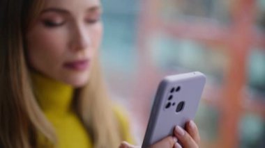 İş kadını, şehir manzaralı pencerenin önünde cep telefonuyla mesajlaşıyor. Ciddi bir iş kadını eve akıllı telefon mesajı gönderiyor. İnternetten alışveriş yapan güzel bir kadın cep telefonuyla alışveriş yapıyor..